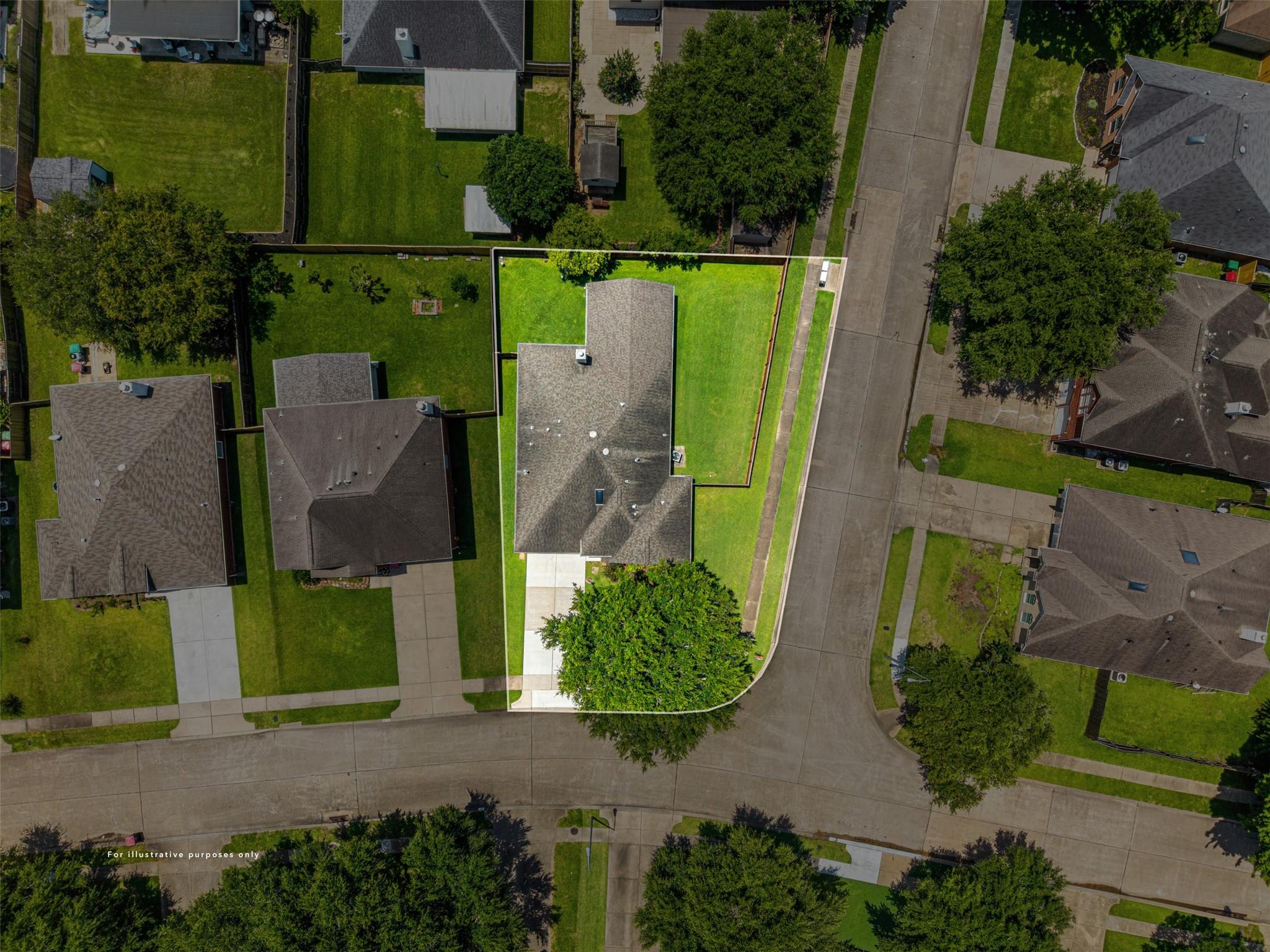 Aerial view of a suburban home and green lot outlined beside a residential street.