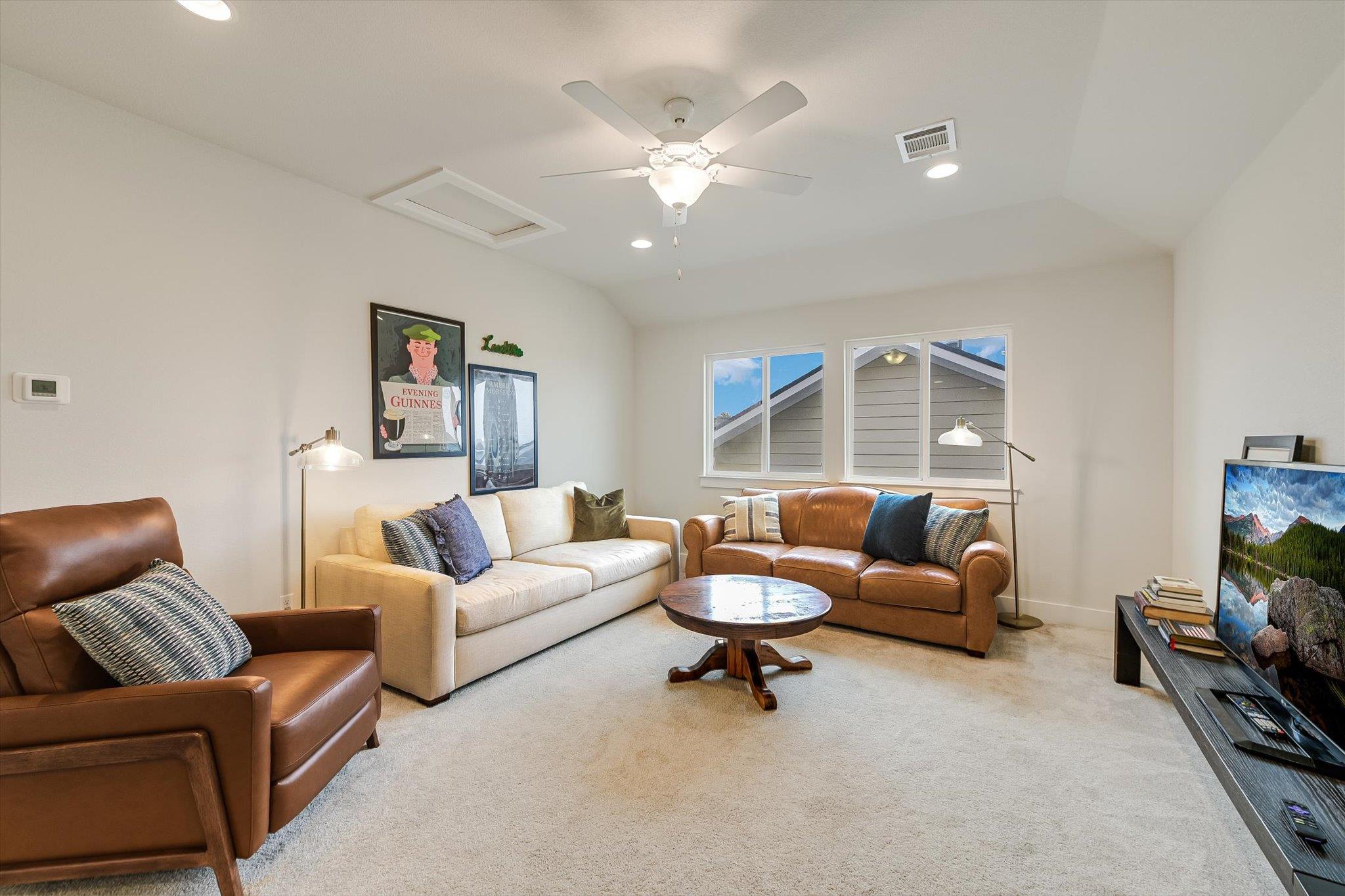 Living room with a white sofa, brown leather seating, and a round wooden coffee table.