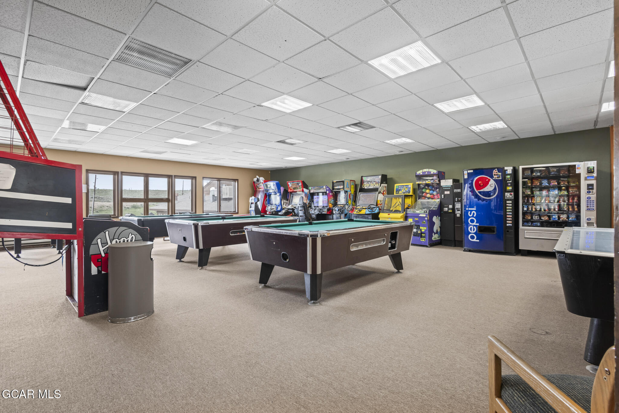 Recreation room with pool tables, arcade games, and vending machines.
