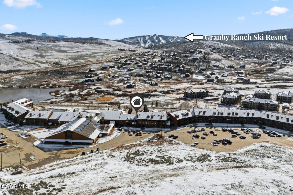 Aerial view of a snow-covered Granby resort complex, with ski runs on the mountain behind it.