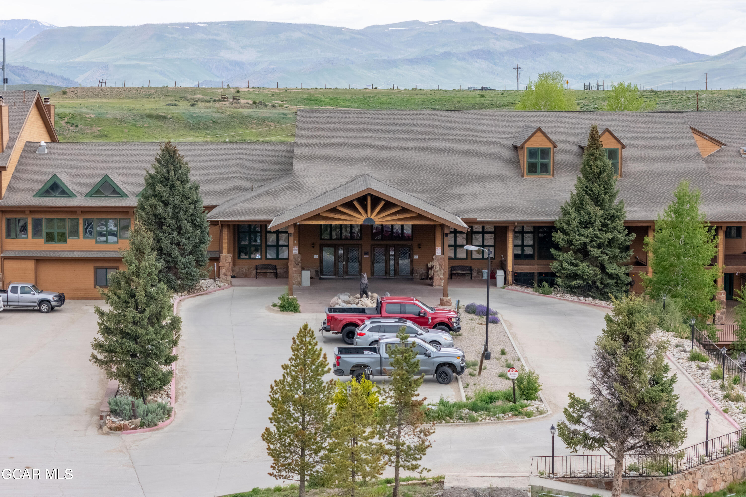 Lodge-style property with a covered entrance and mountain backdrop.