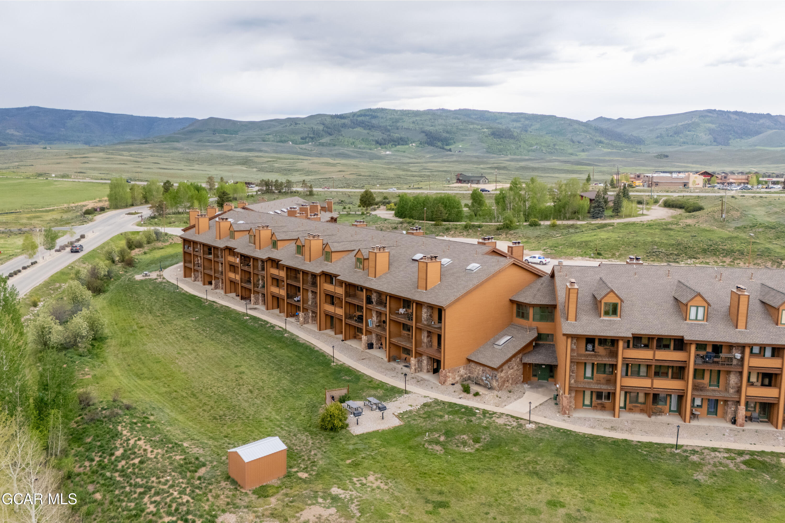 Aerial view of a multi-story condominium complex with balconies and mountain views.