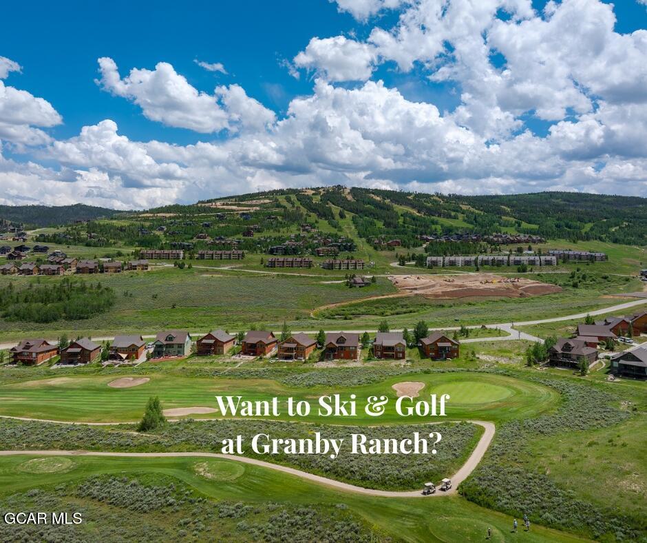 Aerial view of Granby Ranch homes and golf course, with green mountain slopes and a cloud-filled sky.