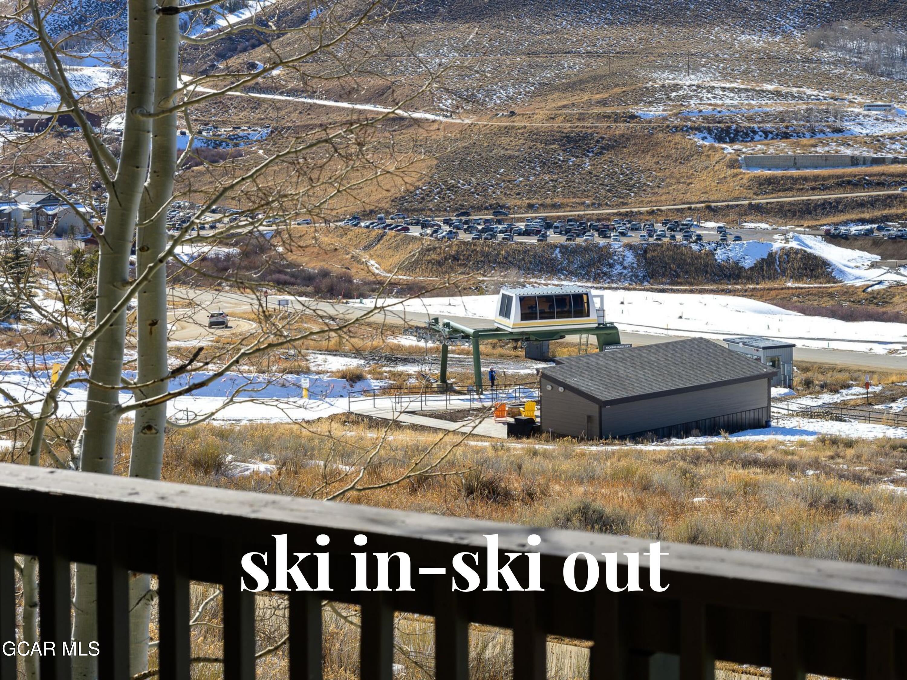 Ski-in, ski-out view of a ski lift and snowy slopes from a balcony.
