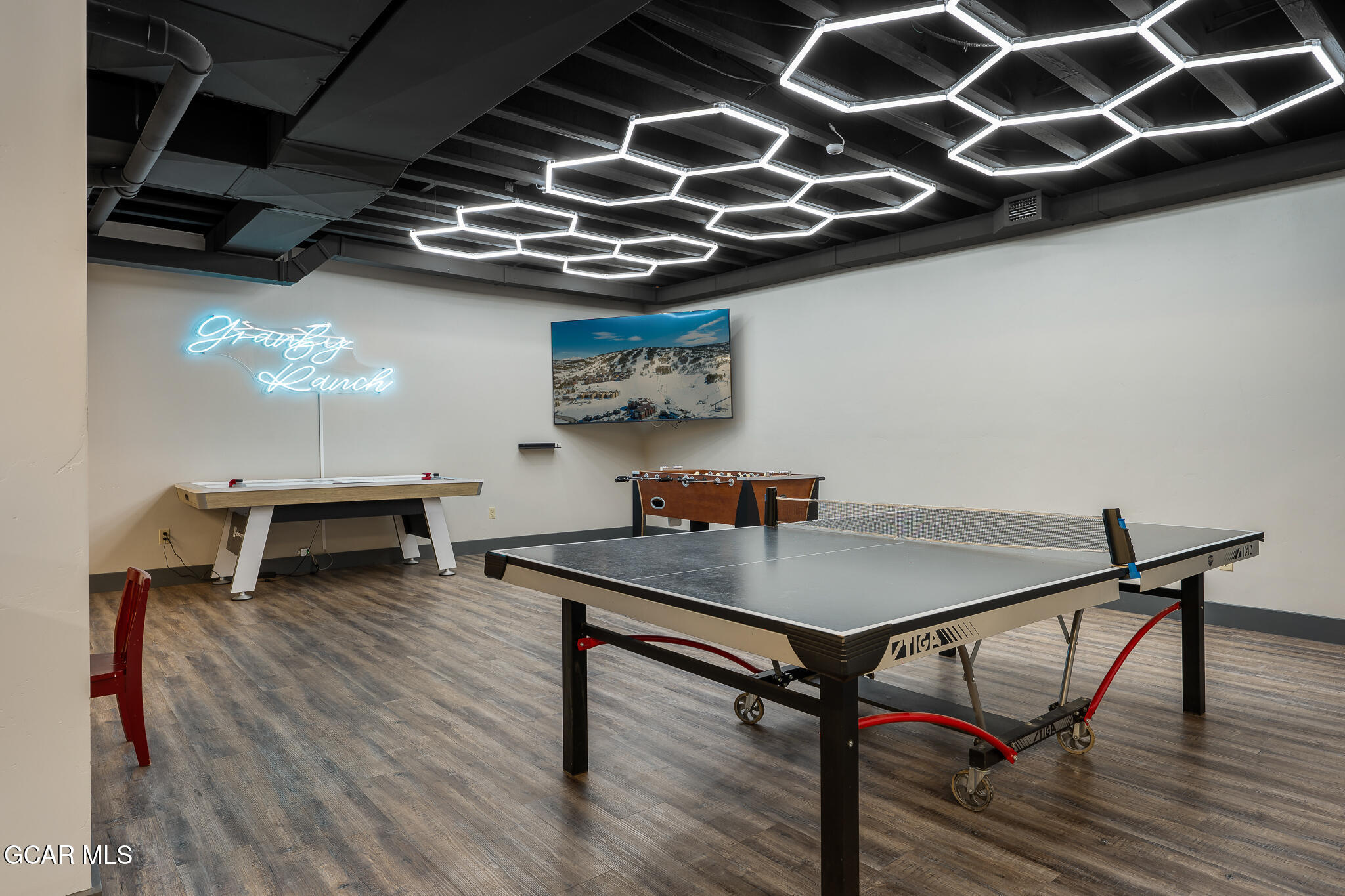 Game room with a ping-pong table, foosball and air hockey tables, and a glowing Granby Ranch sign.