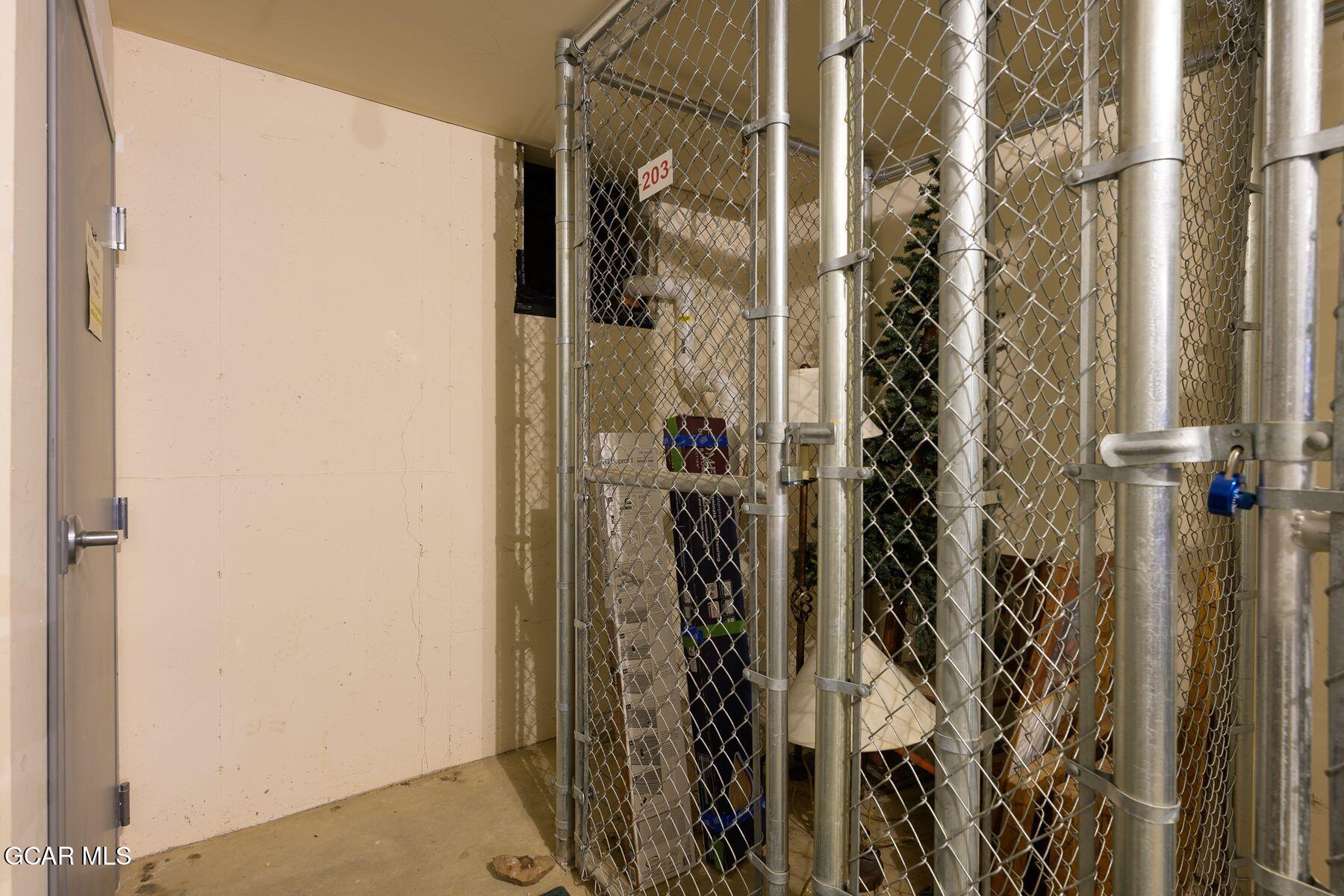 Storage cage marked 203 behind a chain-link fence in a building interior.