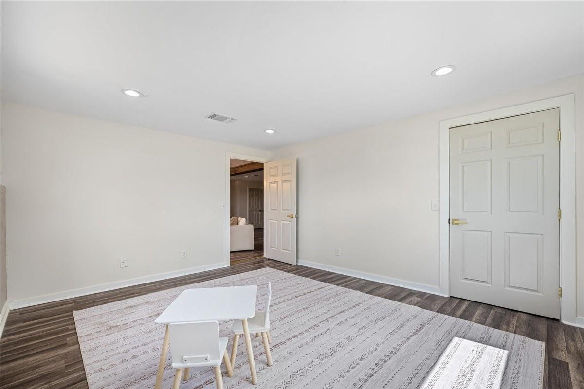 Bright room with a patterned rug, small white table and chairs, and white double doors.