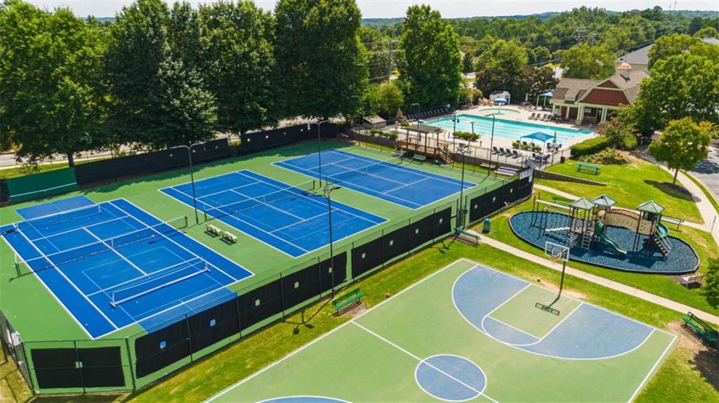 Aerial view of community tennis courts, swimming pool, playground, and basketball court.