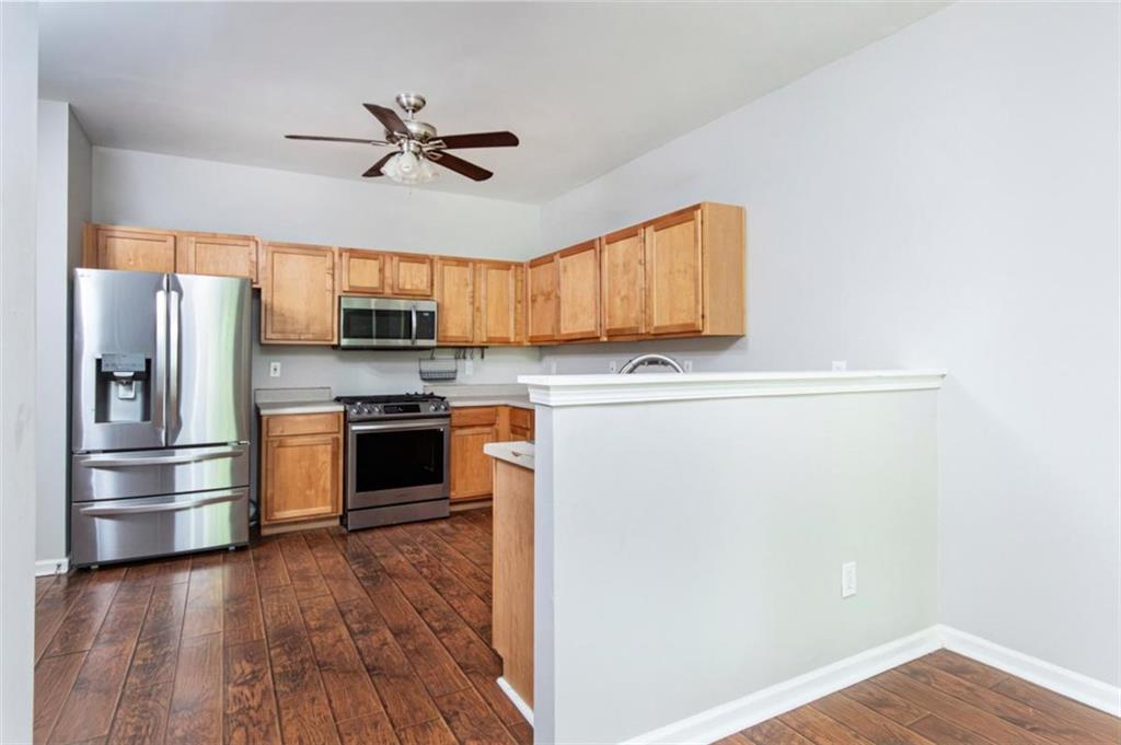 Kitchen with natural wood cabinets, stainless steel appliances, and a raised peninsula.