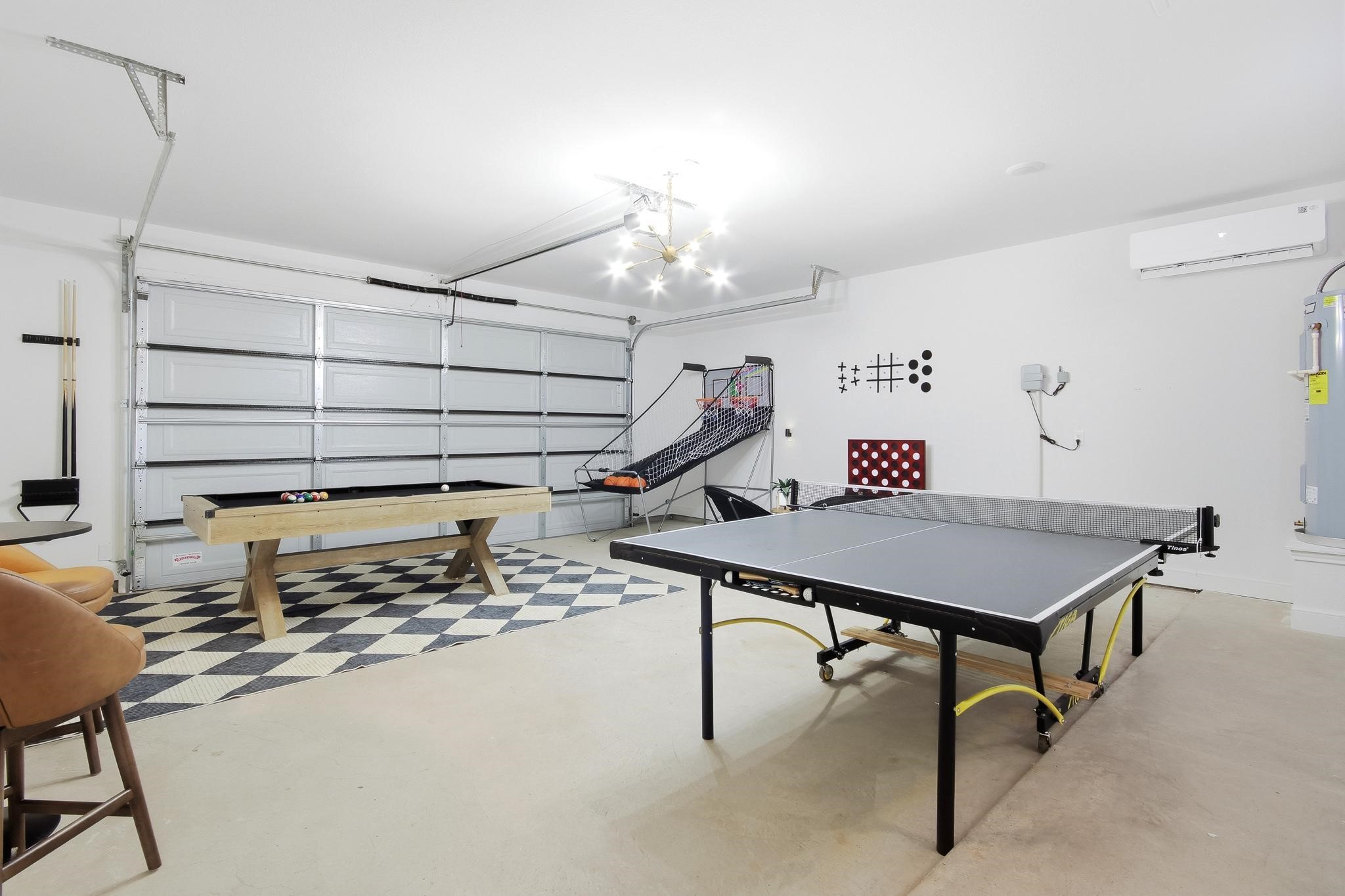Garage game room with a table-tennis table, pool table, basketball arcade game, and geometric rug.