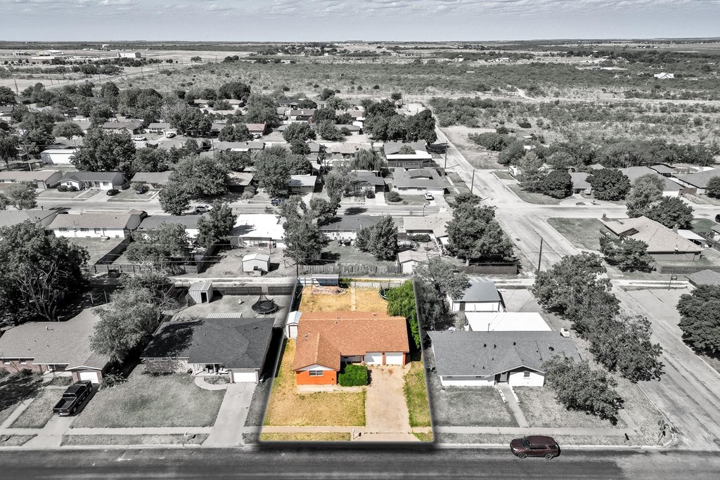 Aerial view of a single-story orange-roofed home and its lot among Snyder neighborhood homes.