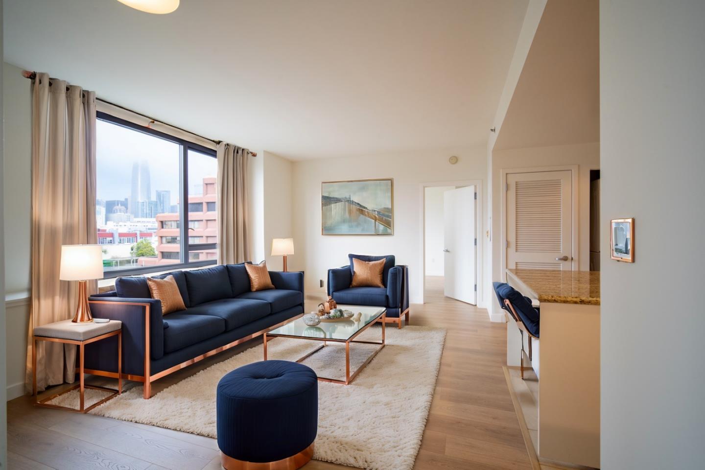 Living room with navy seating, copper accents, and city views through large windows.
