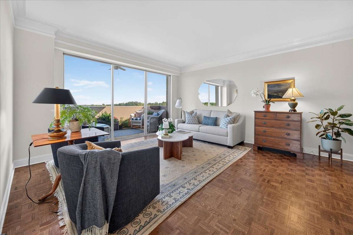 Furnished living room with parquet floors and sliding glass doors opening onto a terrace.