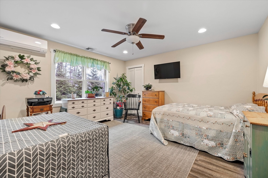 Bedroom with two beds, a large curtained window, and a wall-mounted television.