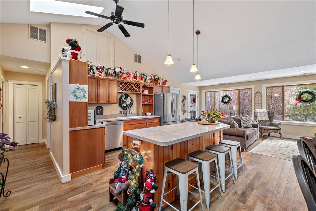 Open-plan kitchen and living area with a large island, vaulted ceiling, and Christmas decorations.