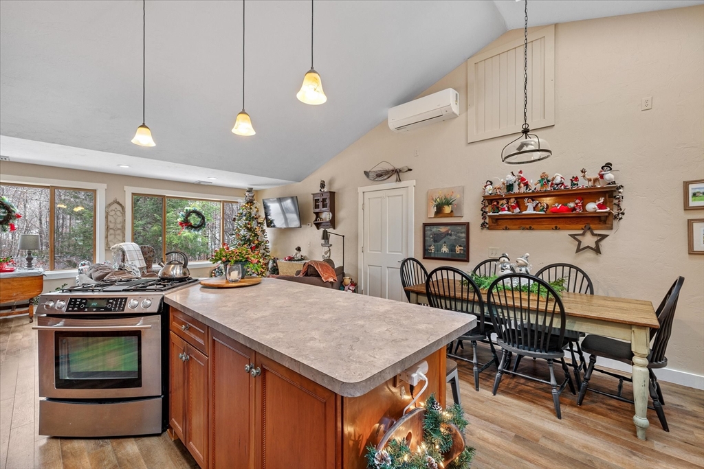 Kitchen and dining area with a large island, stainless steel range, and decorated Christmas tree.