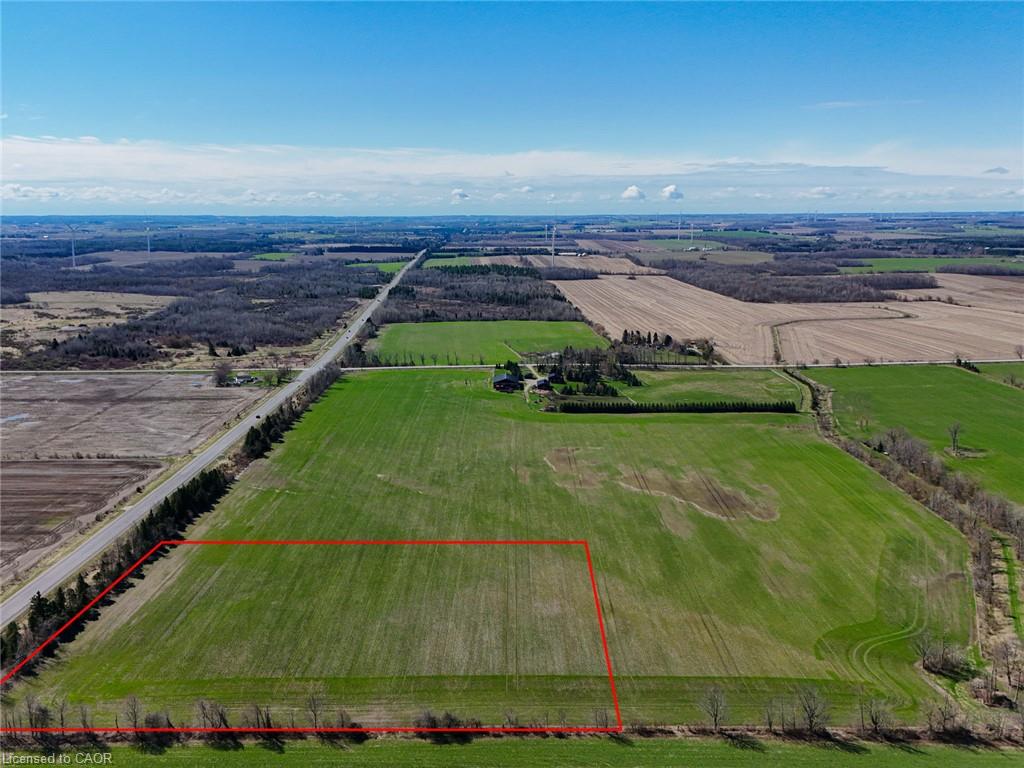 Aerial view of farmland outlined in red, beside a rural road and surrounded by fields.