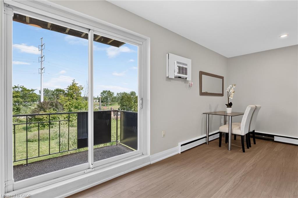 Dining area with a small table and chairs beside a sliding glass door to a balcony.