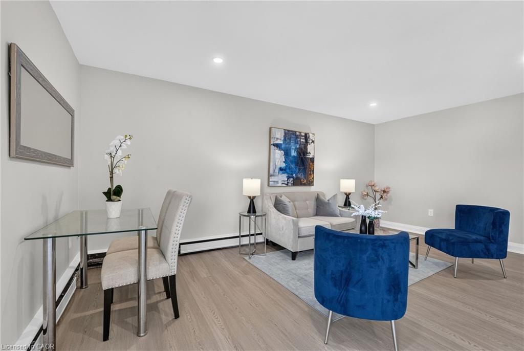 Living room with a gray sofa, vivid blue armchairs, and a glass-top dining table.