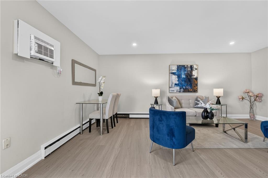 Living room with a gray sofa, blue accent chairs, glass coffee table, and dining nook.