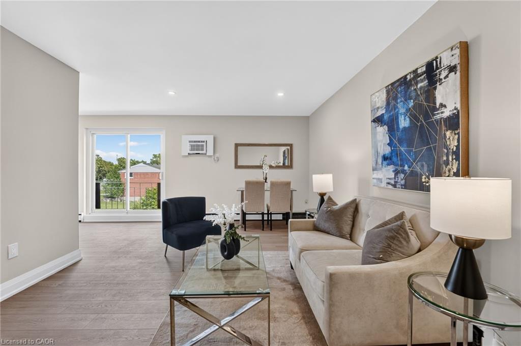 Staged living room with beige sofa, navy chair, glass coffee table, and sliding doors to a balcony.