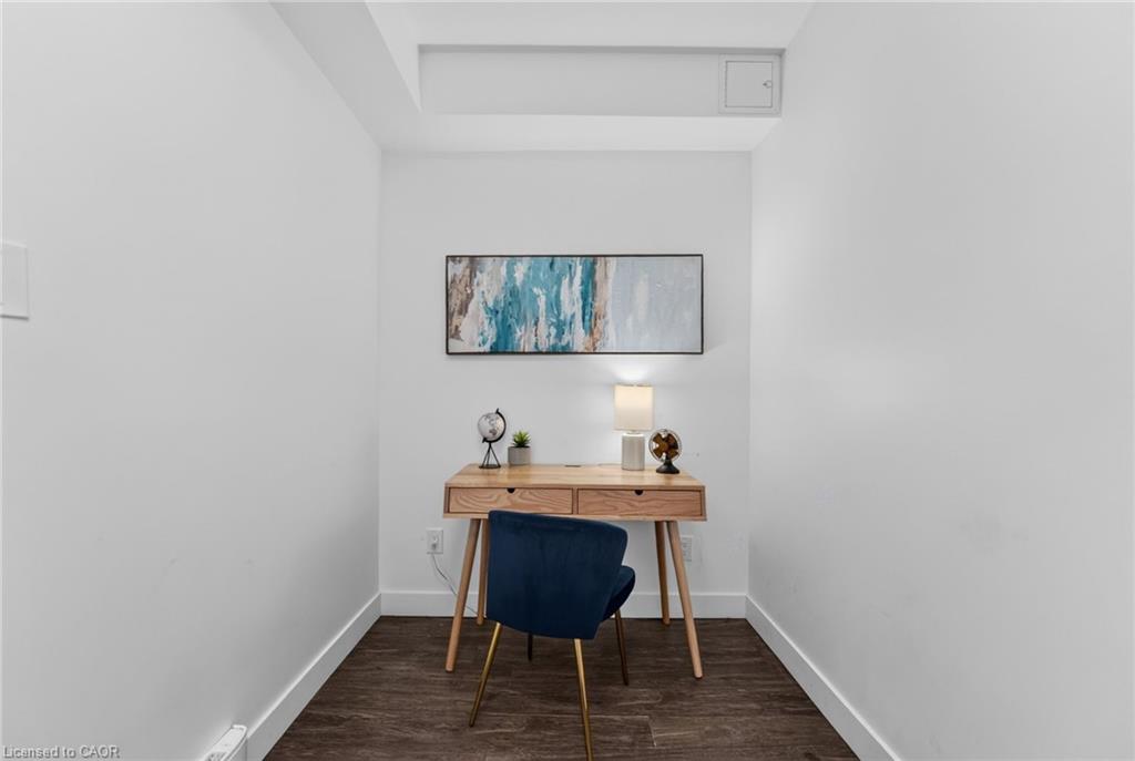 Home office with a wooden desk, blue chair, and abstract wall art.