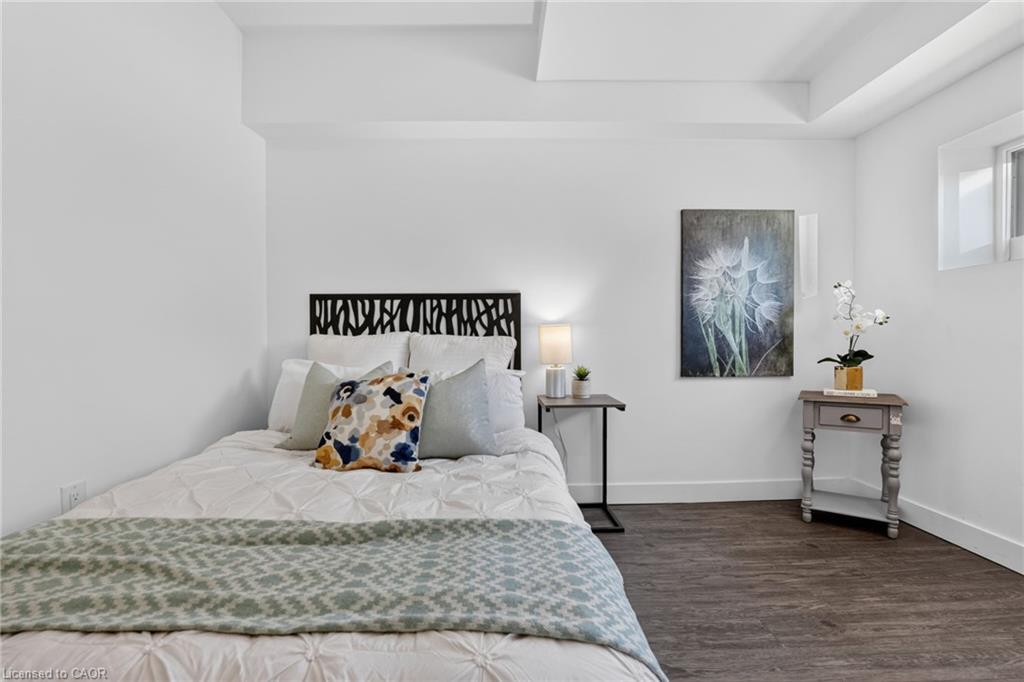 Staged bedroom with a patterned bedspread, black headboard, and floral wall art.