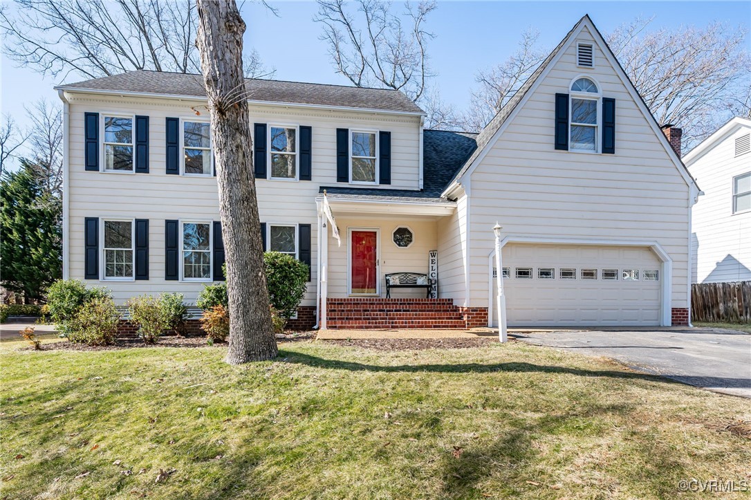 White two-story house with a red front door, brick steps, and an attached garage.