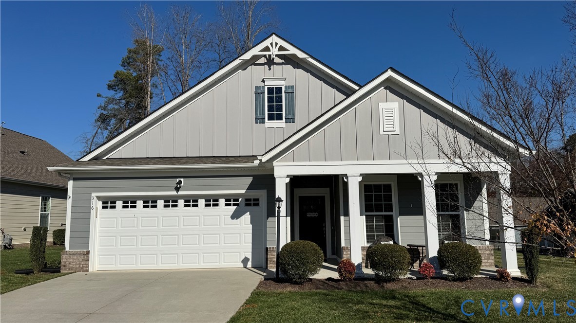 Gray-sided house with a two-car garage and covered front porch.