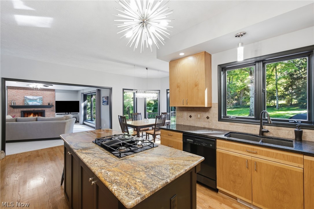 Kitchen with a granite island and gas cooktop, opening to the dining and living areas.