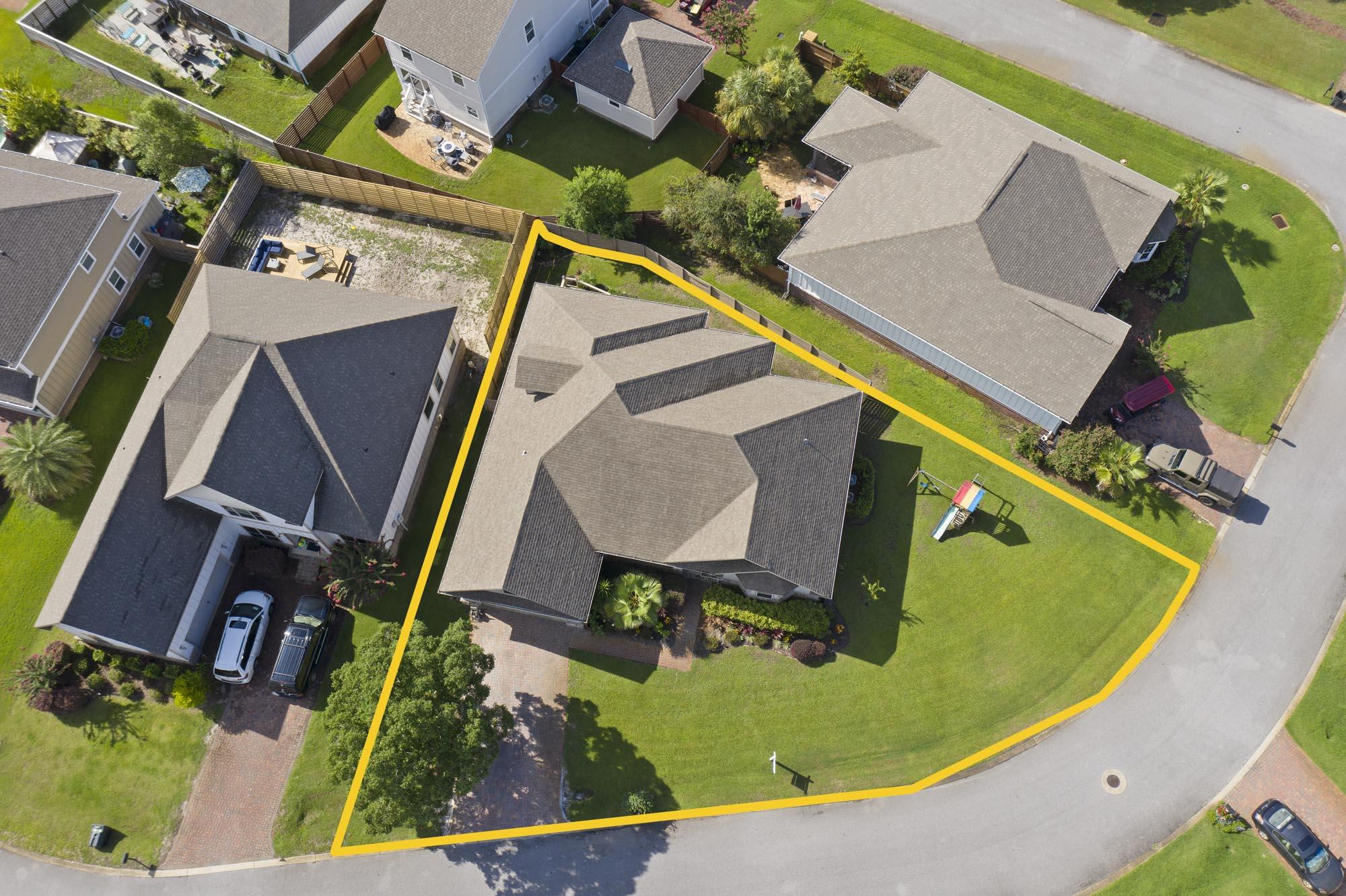 Aerial view of a home and its yellow-outlined lot on a curved residential street.