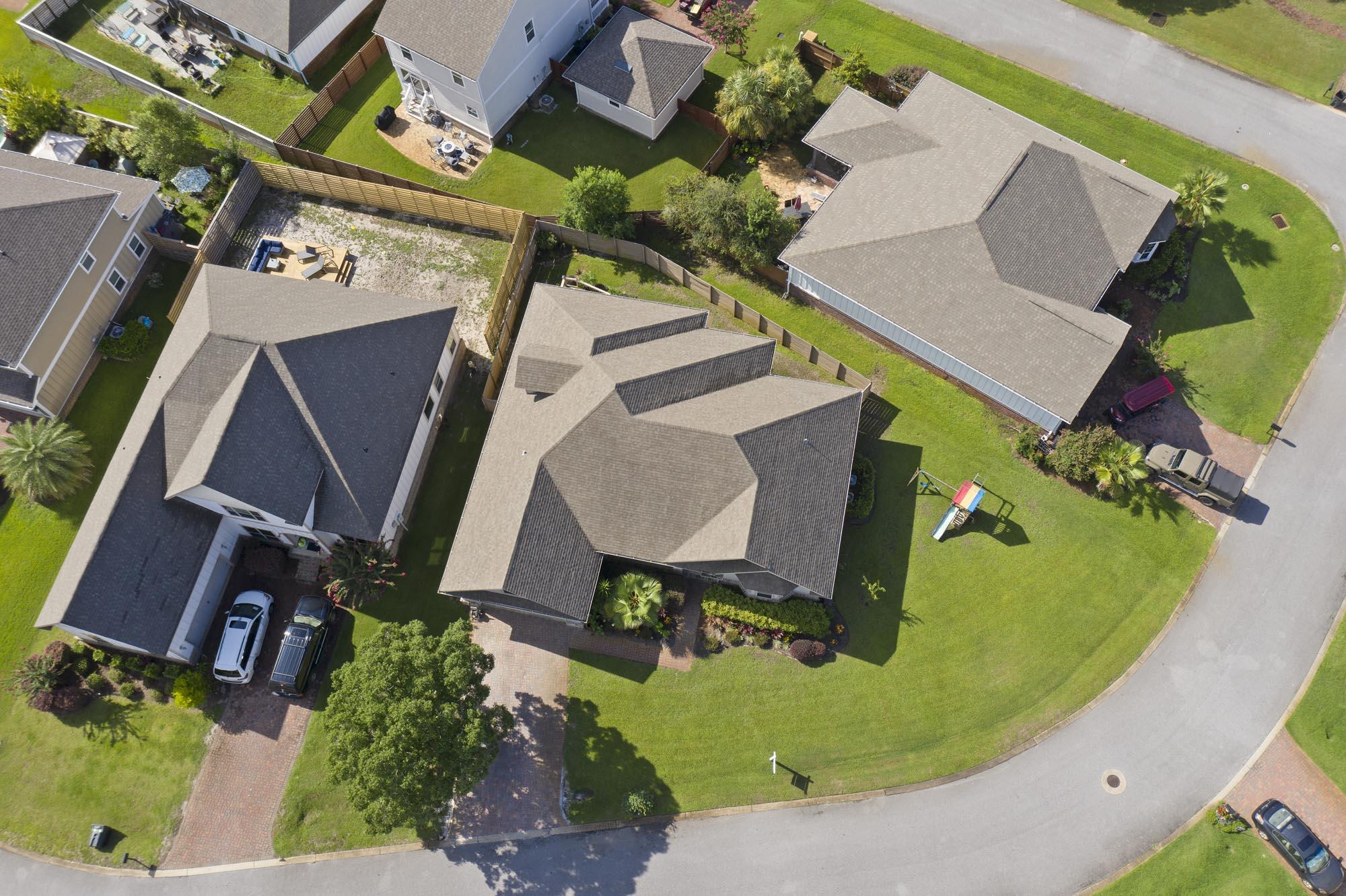 Aerial view of a home with a multi-gabled roof, landscaped front lawn and driveway.