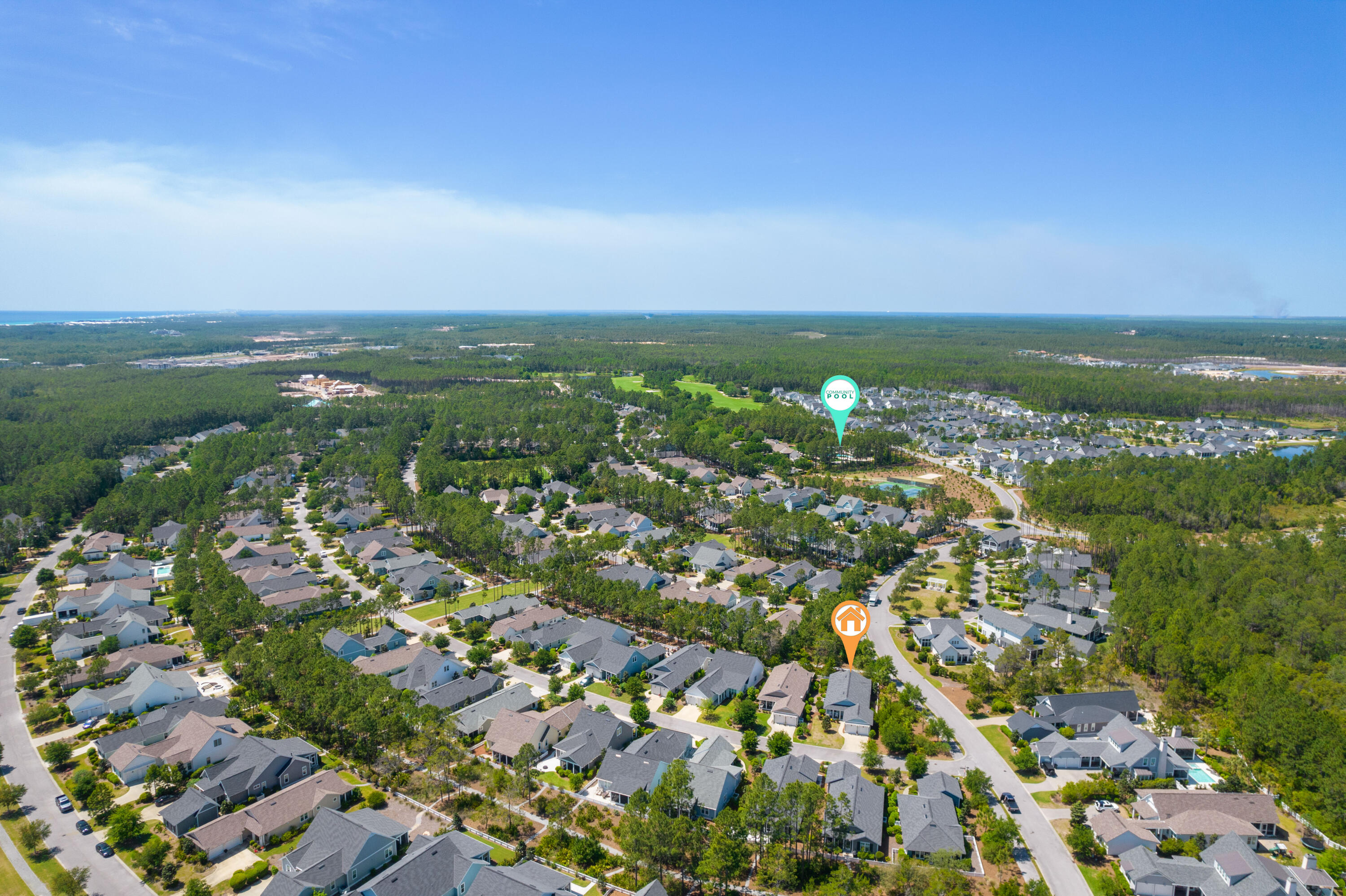 Aerial view of a tree-lined neighborhood, with markers showing the property and community pool.