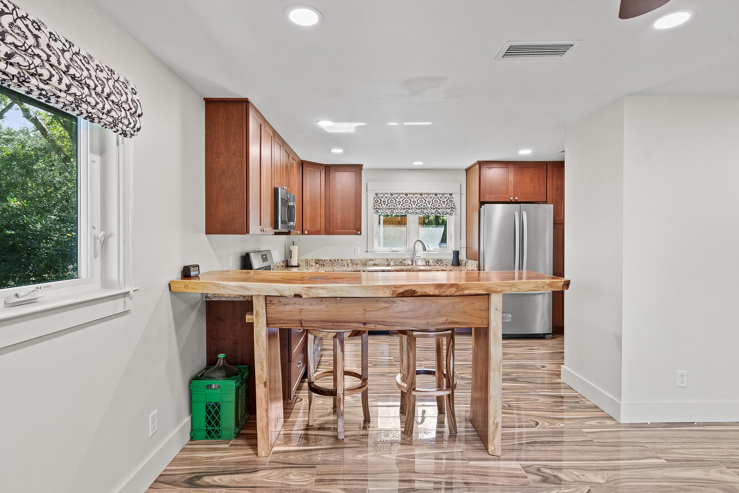 Kitchen with a large natural-wood island, reddish-brown cabinets, and stainless steel appliances.