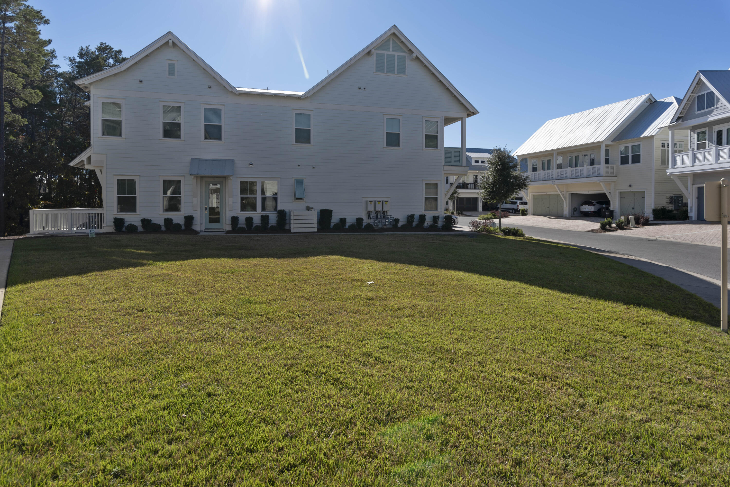 White two-story home with twin front gables behind a broad lawn.