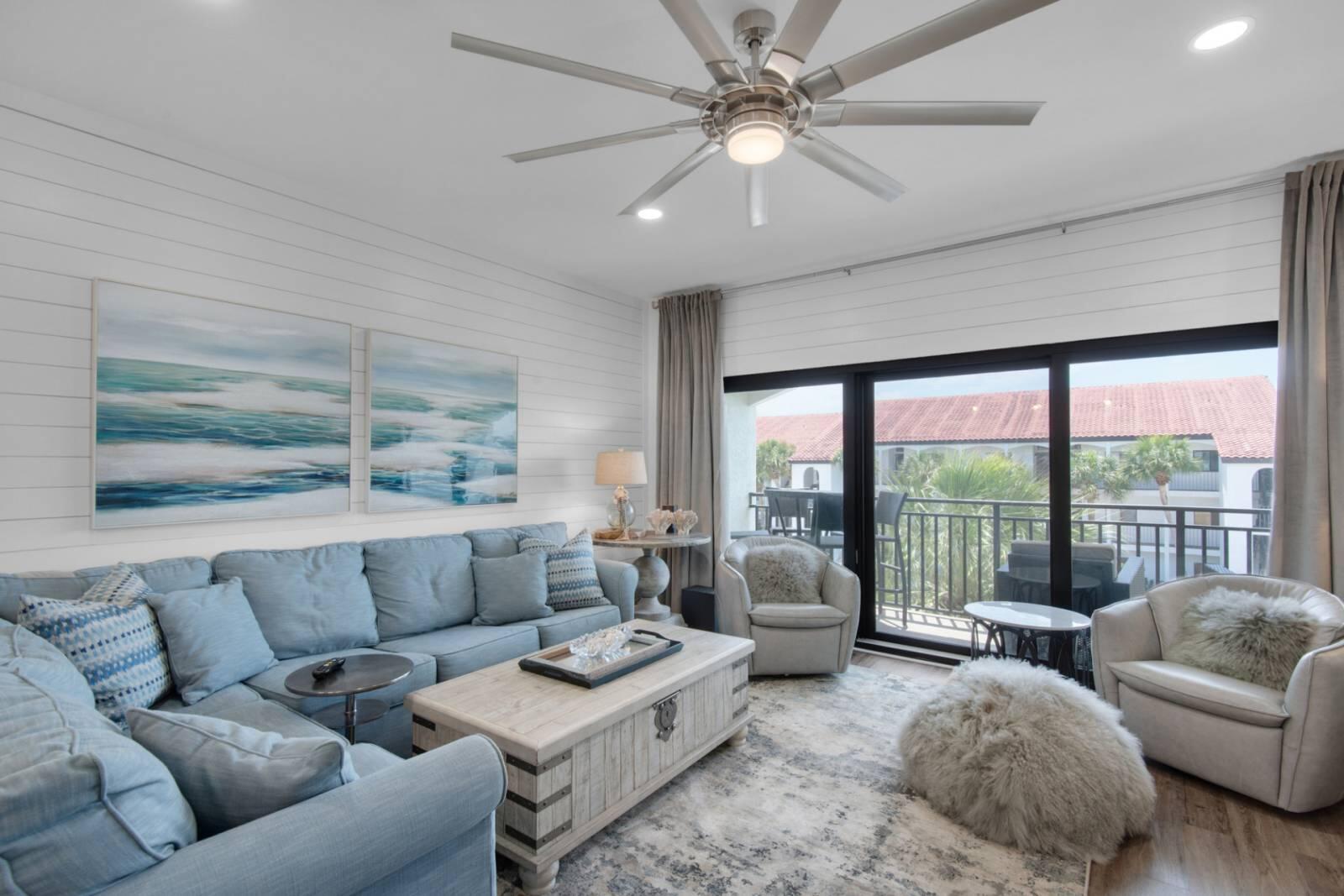 Living room with a blue sectional and sliding doors opening onto a balcony.