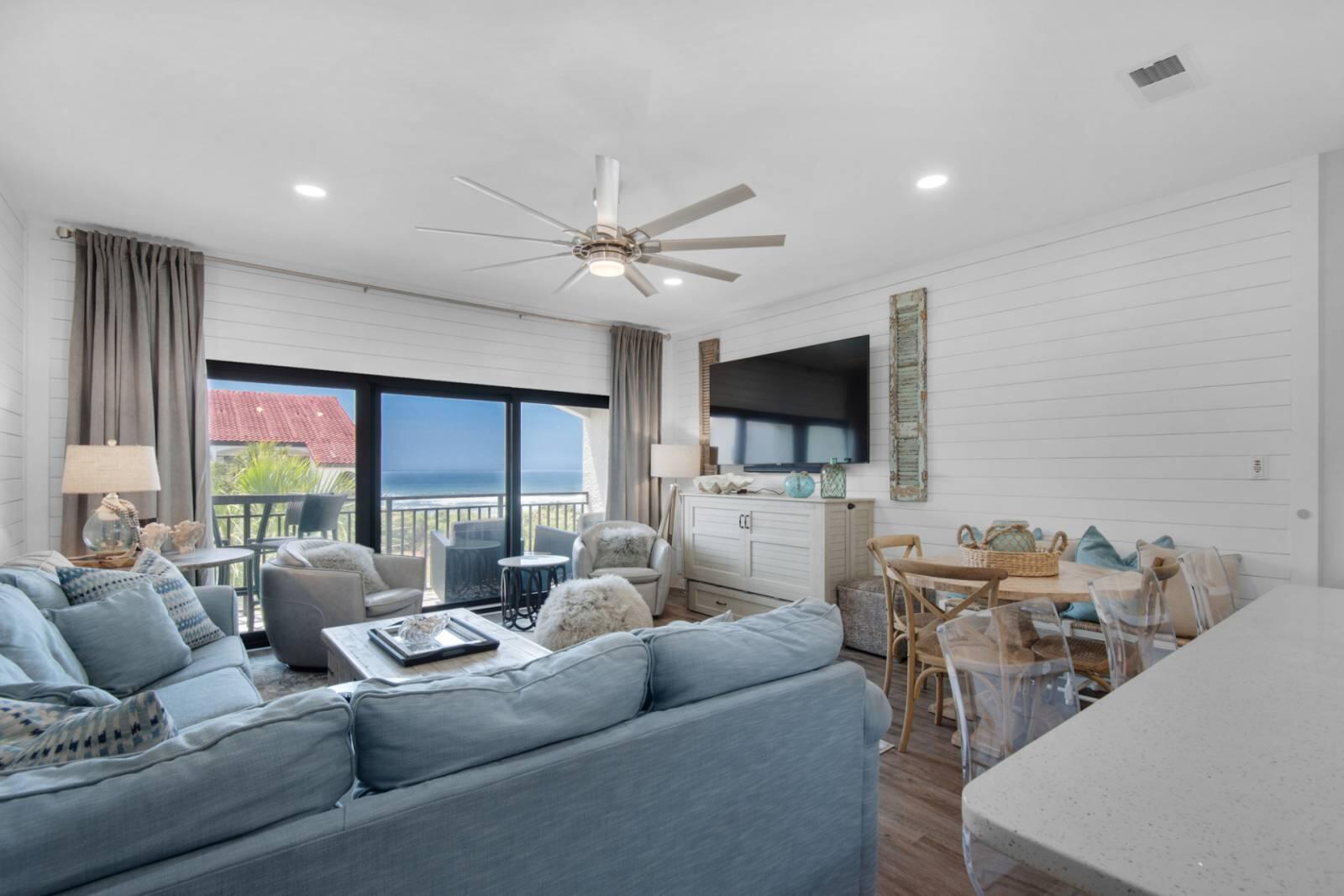Living room with blue sofas and sliding doors overlooking the ocean.