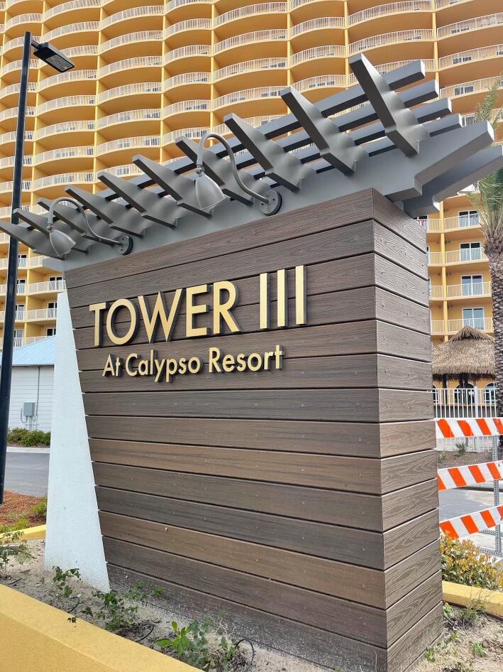 Tower III at Calypso Resort sign in front of a yellow condominium tower.