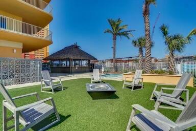 Condo courtyard with turf seating around a fire pit and a shaded gazebo.