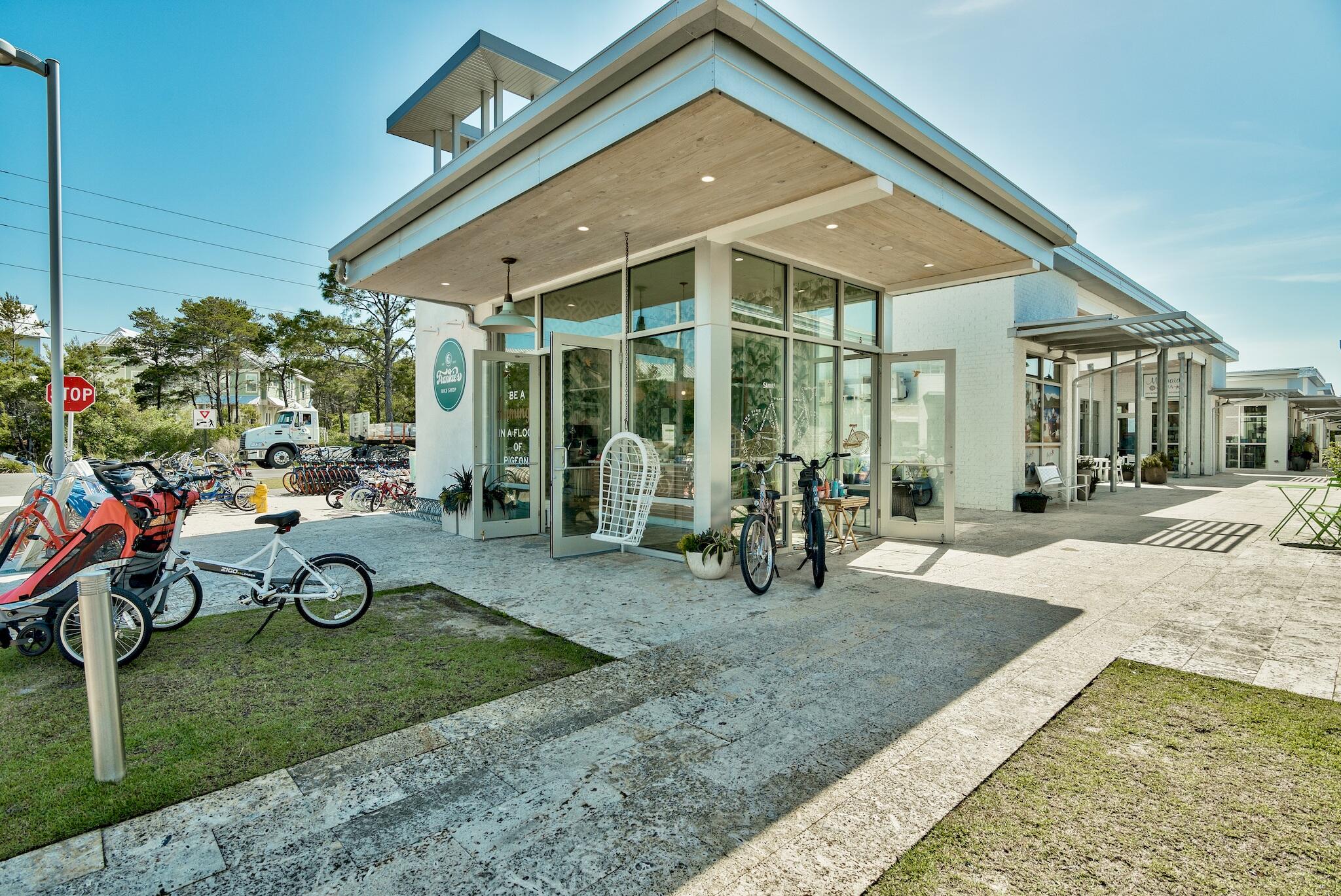 Modern white storefront with a broad wood-paneled overhang and bicycles outside.