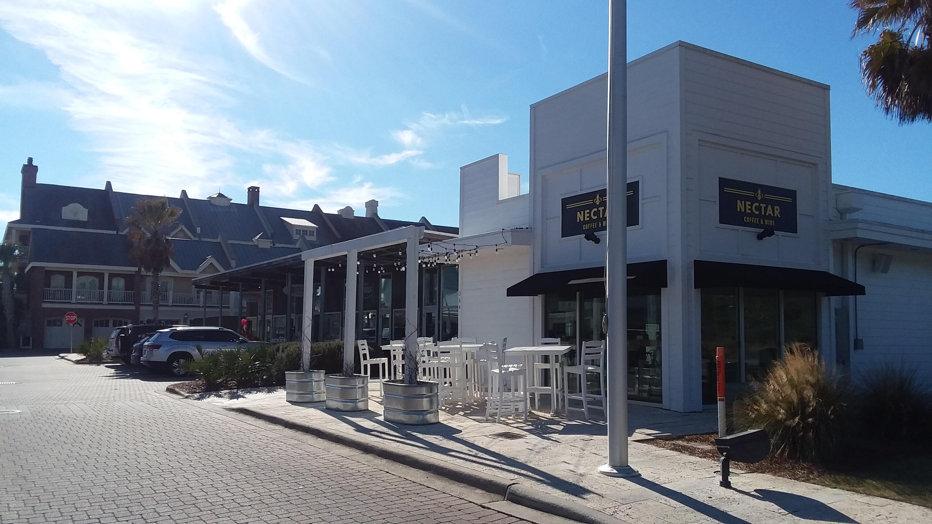 White Nectar Coffee & Wine storefront with outdoor patio seating beside a paved street.