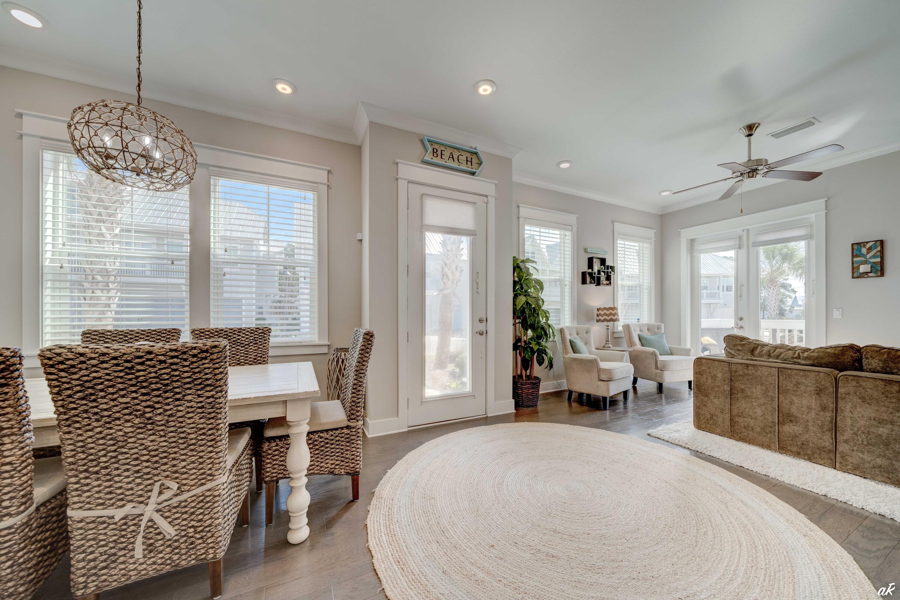 Furnished living and dining room with woven chairs, a brown sectional, and a round rug.