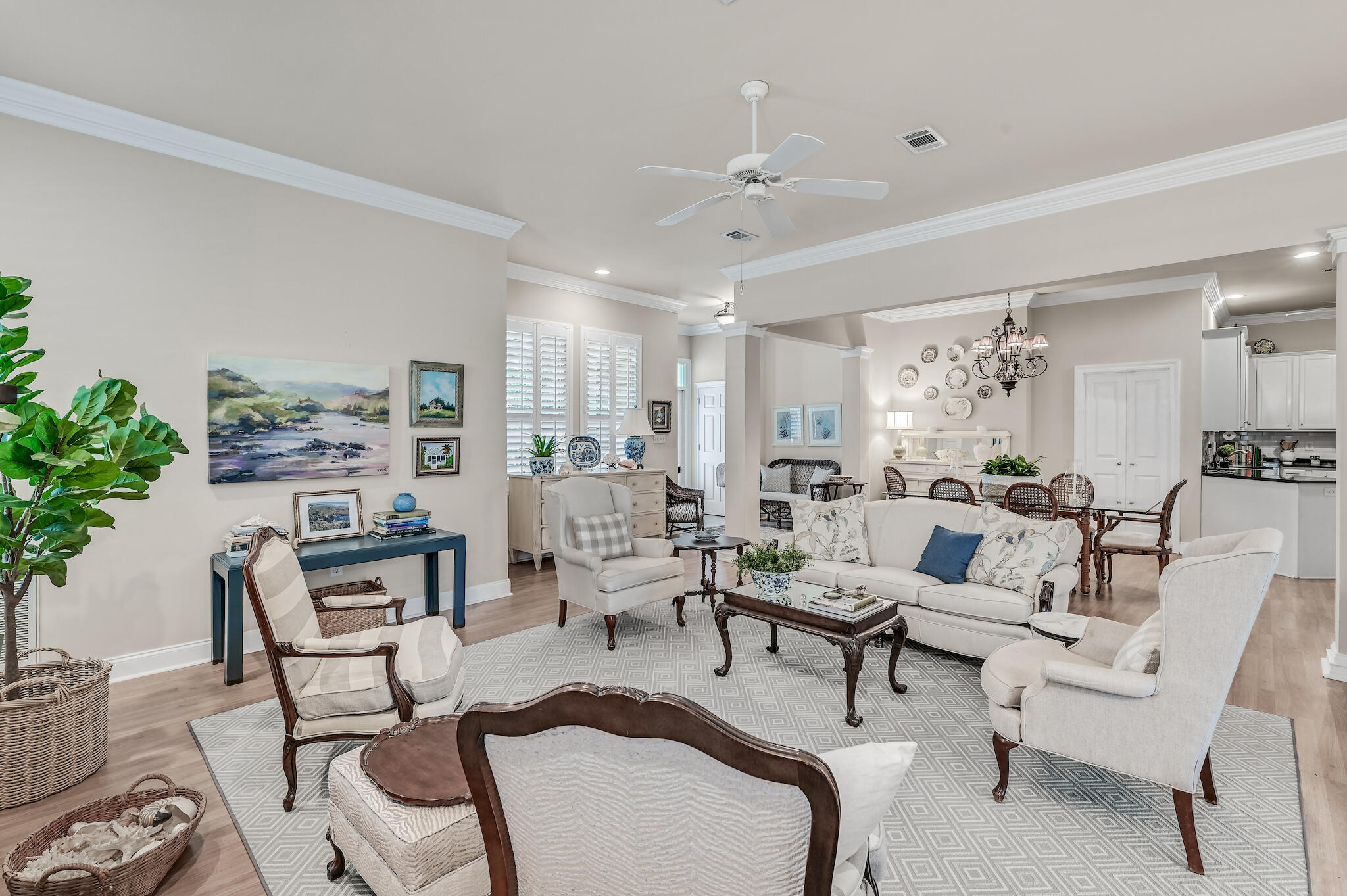 Open-plan living room with a white sofa, patterned rug, and adjoining dining area.