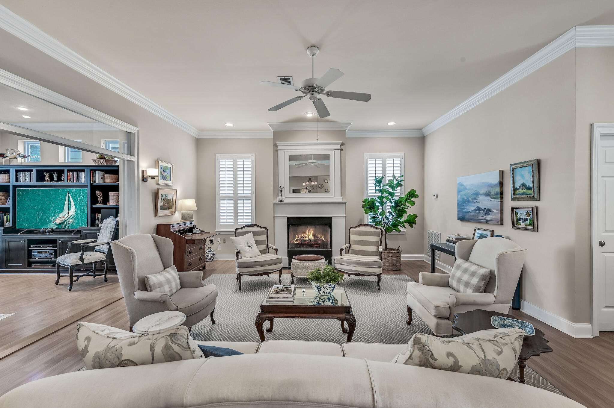 Furnished living room with a central fireplace, patterned rug, and built-in media shelving.