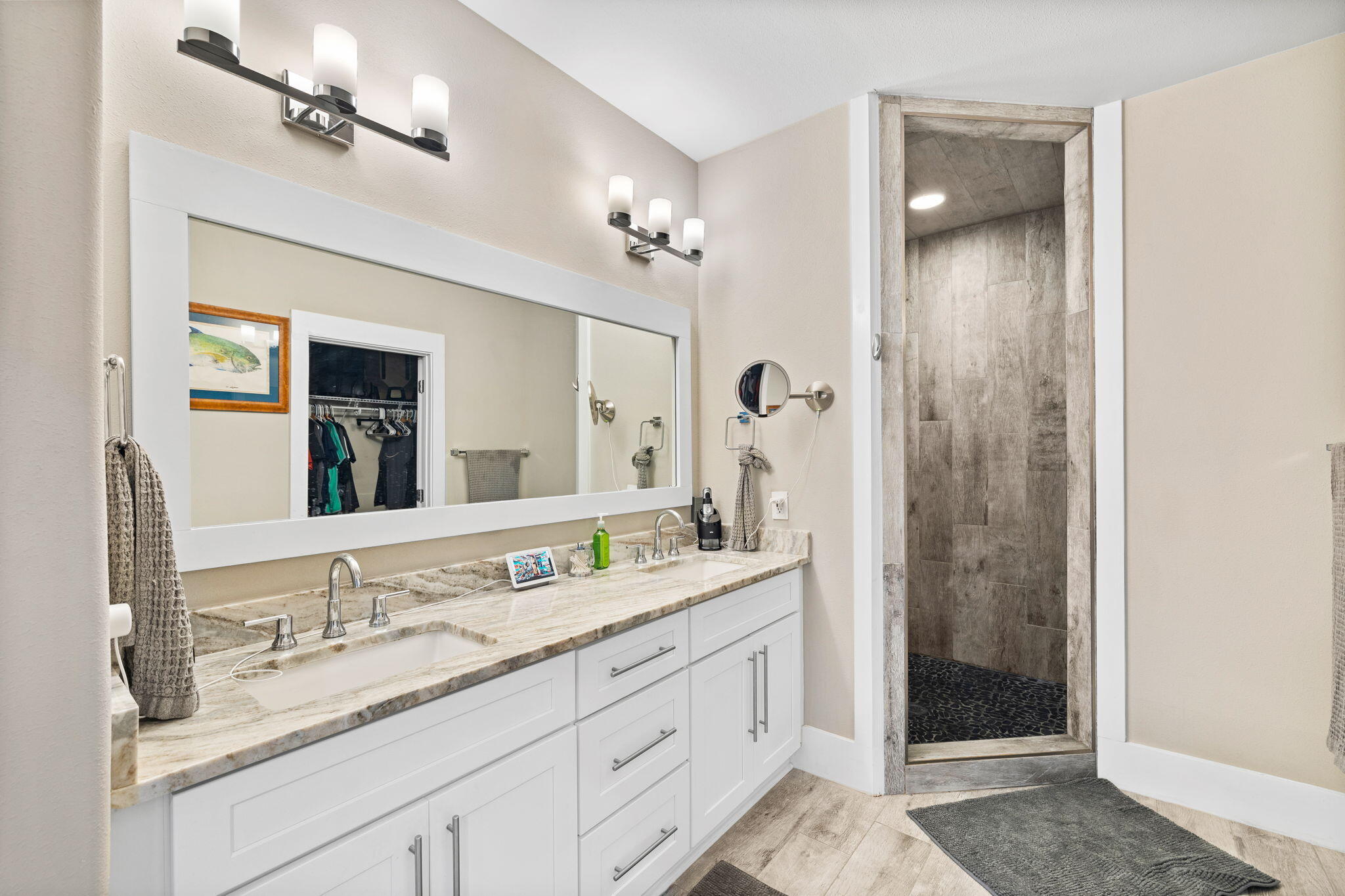 Bathroom with a double-sink vanity and a walk-in gray-tile shower.