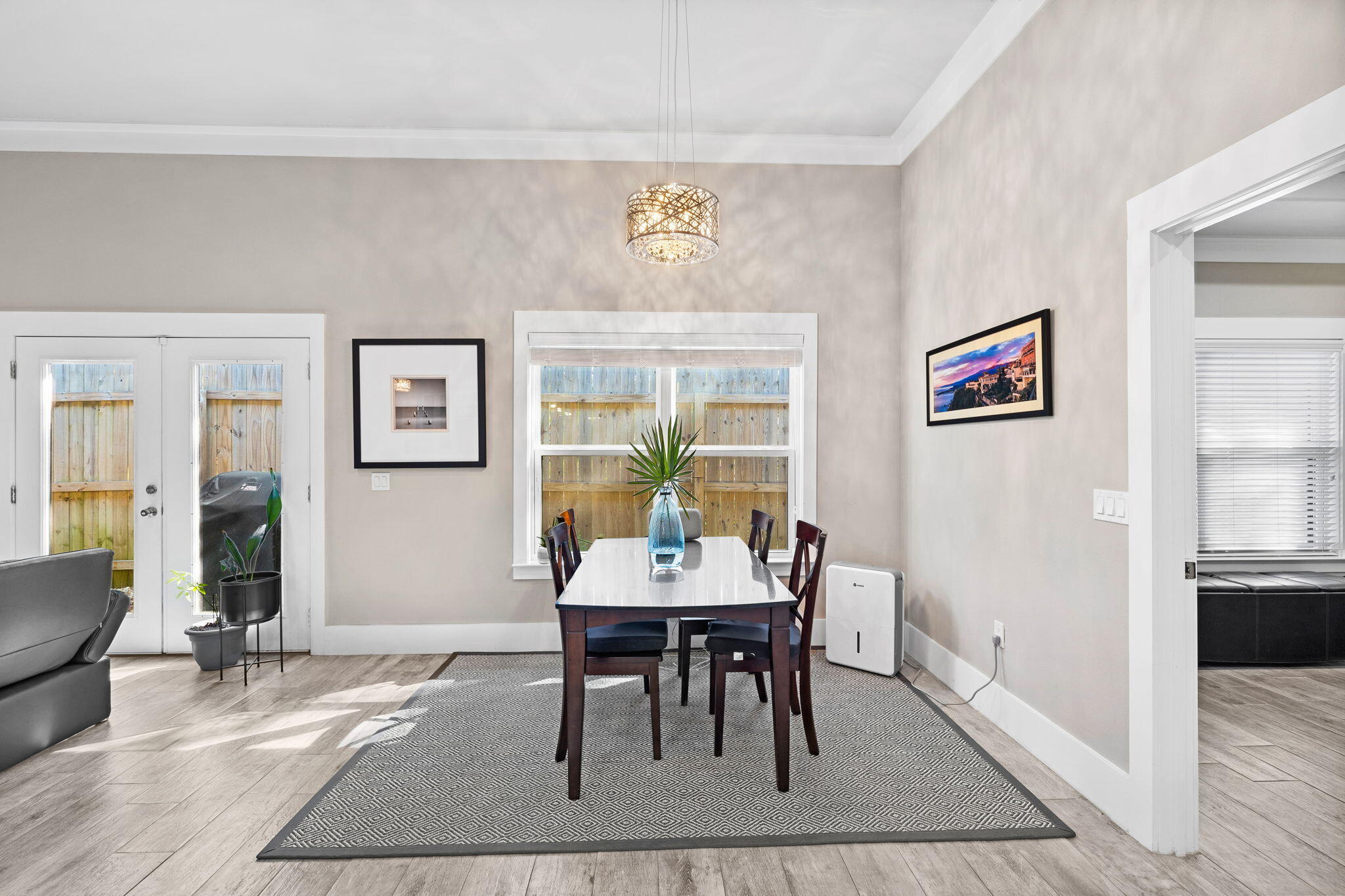 Dining area with a dark wood table, patterned rug, and woven pendant light.