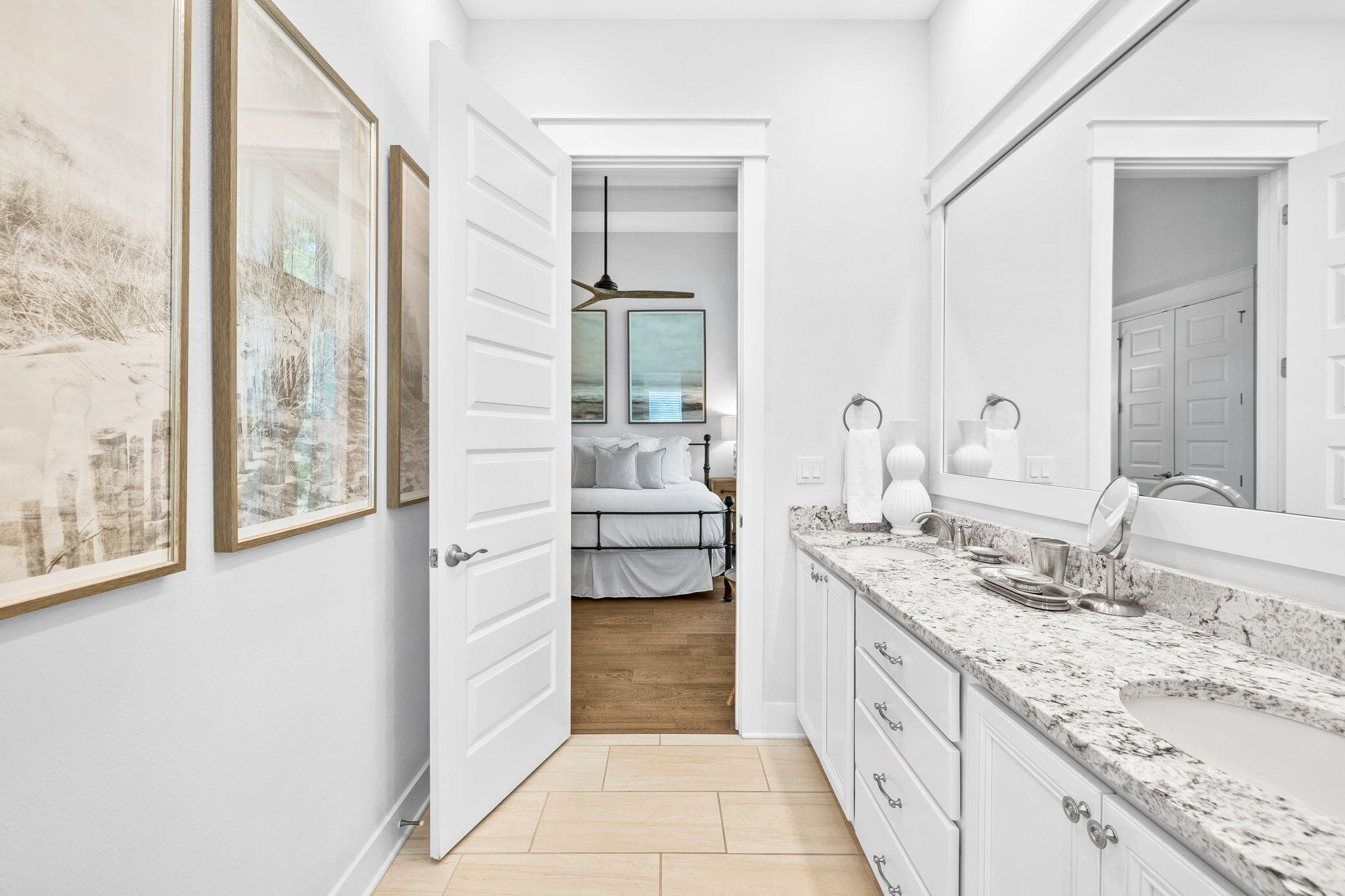 Bright bathroom vanity with granite countertop and a view into the adjoining bedroom.