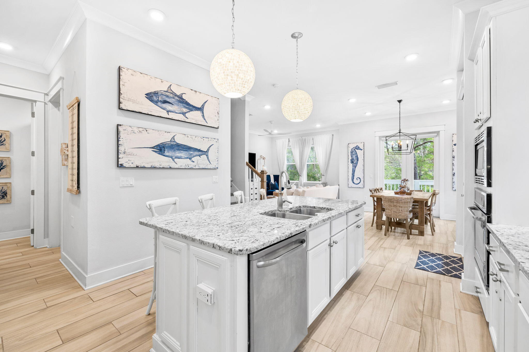 Bright kitchen with a granite island, white cabinetry, and an adjoining dining area.