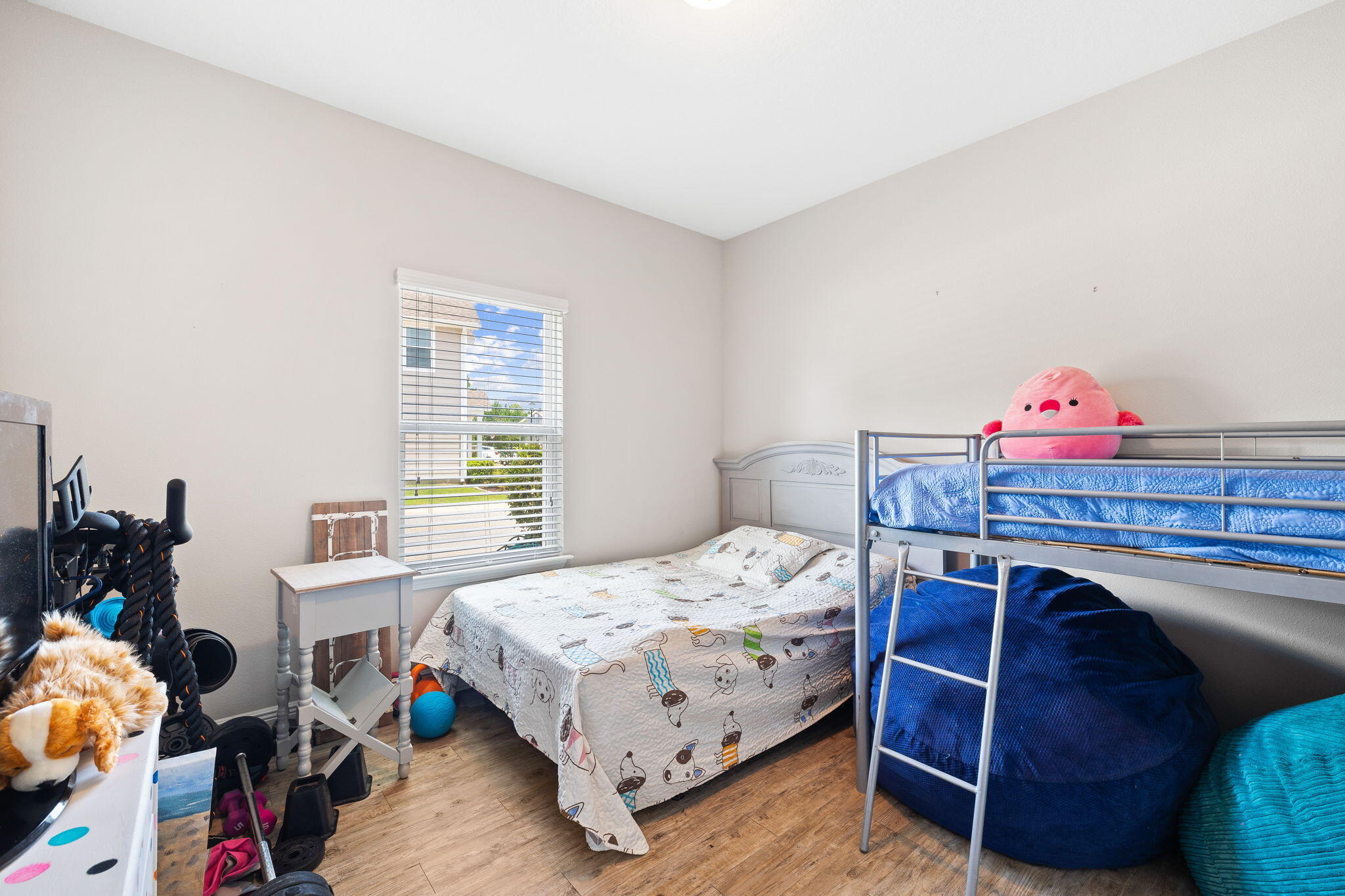 Bedroom with a double bed and metal bunk bed, plush toys, and blue beanbag seating.
