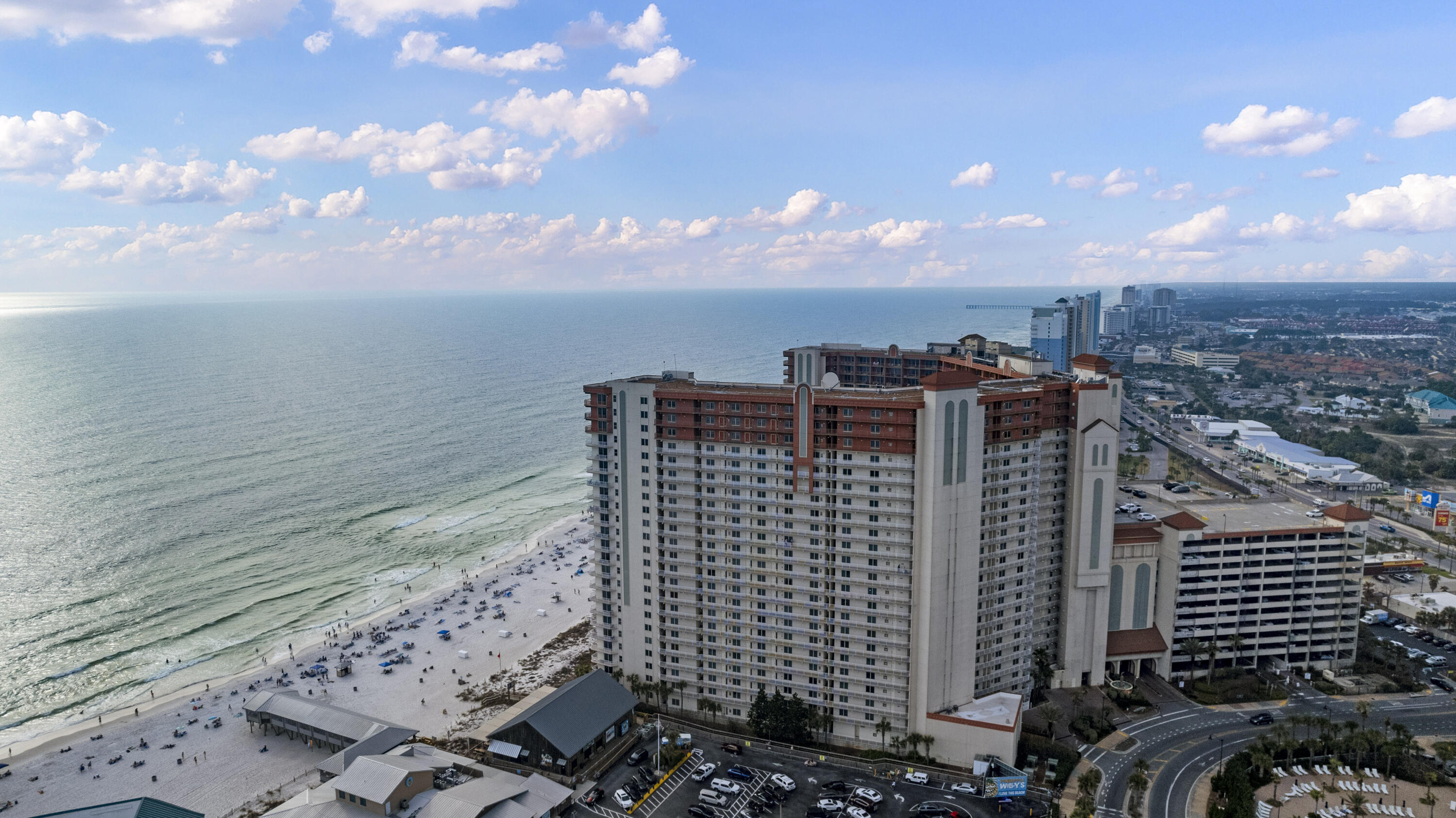Beachfront condominium beside the sandy shore, with the Gulf and coastal city in view.
